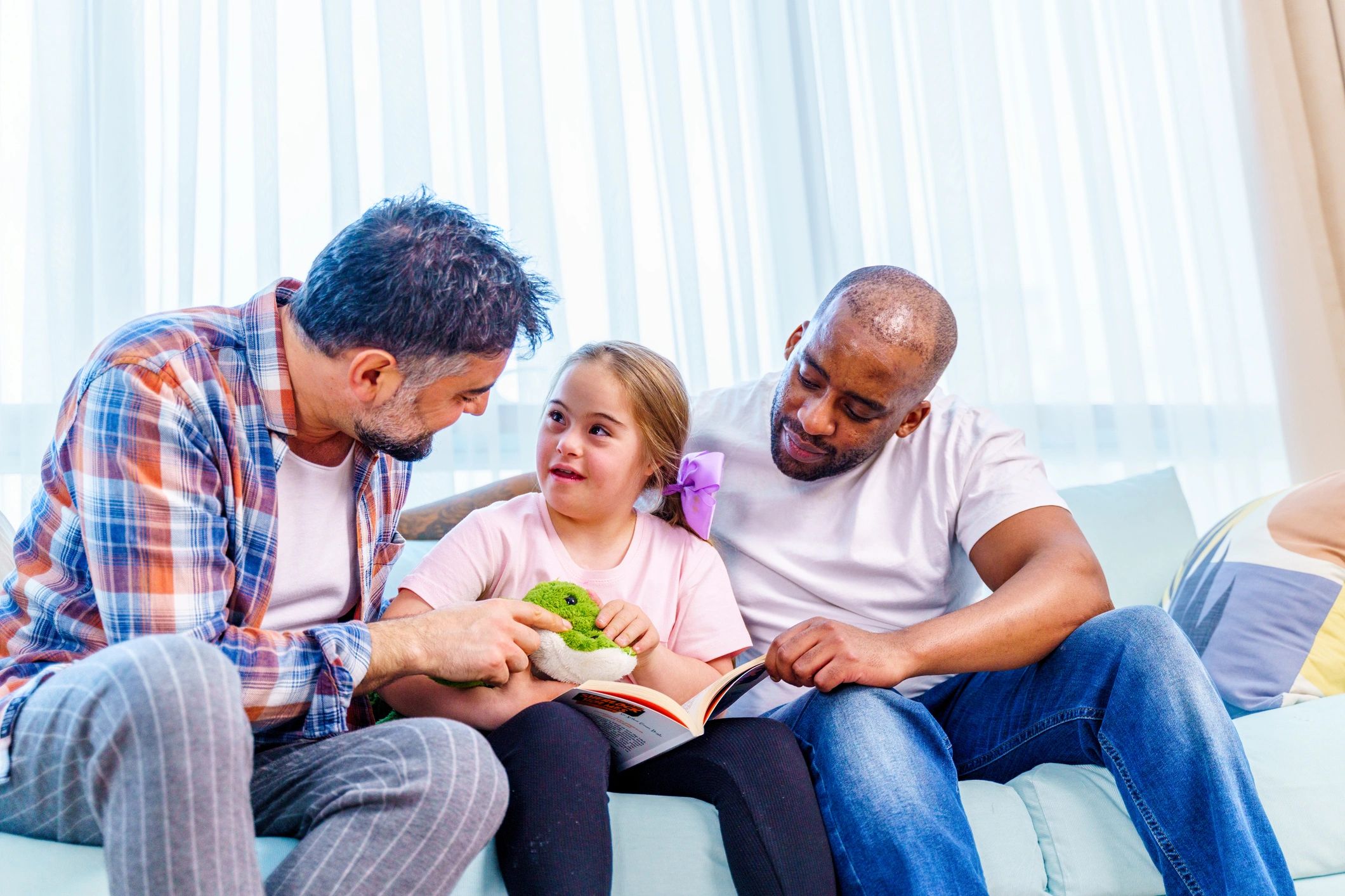 Family reading a book together on the couch at home