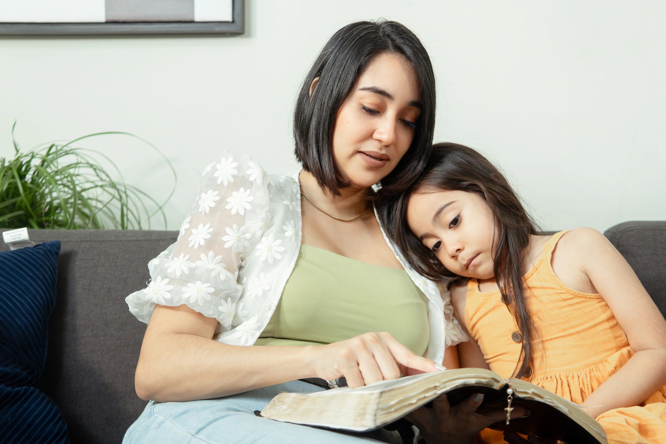 Parent and child reading a book at home